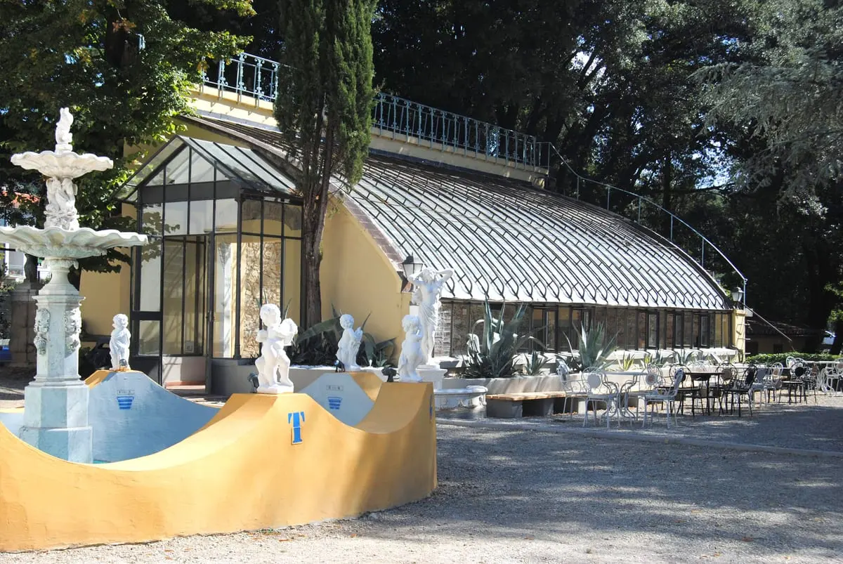 La serra ottocentesca in vetro e ferro, con la fontana davanti